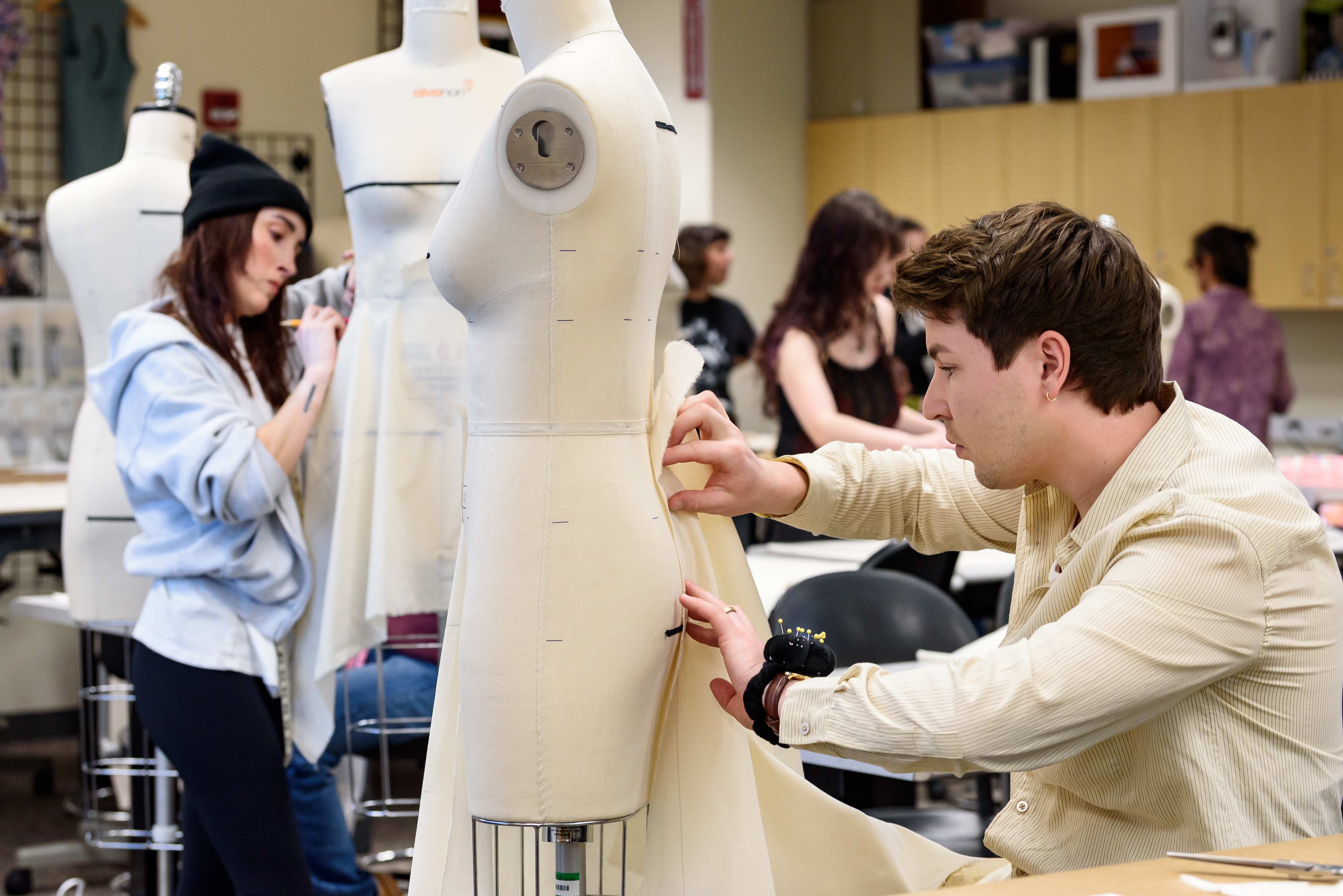 students working with fabric on dress forms
